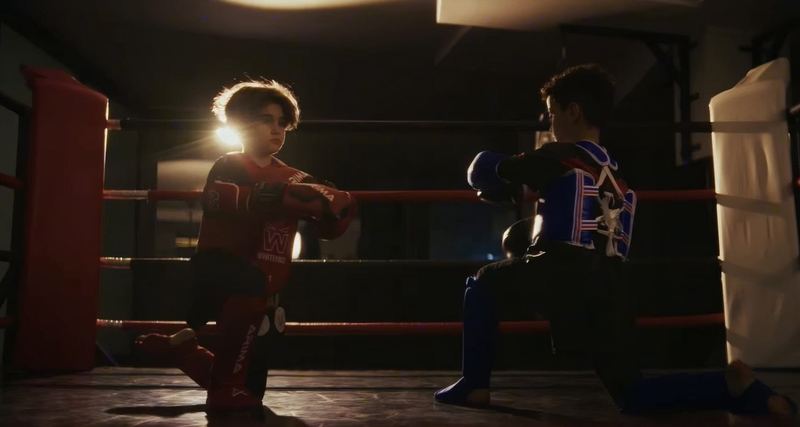 Genç sporcular ringde koruyucu ekipmanla sparring yaparken
