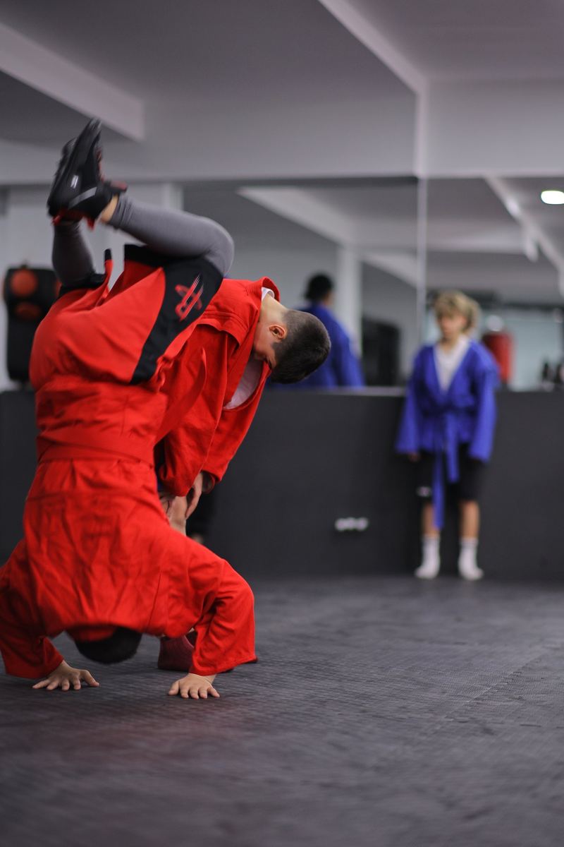 Kırmızı sambo ceketli sporcu, el üstü hareket